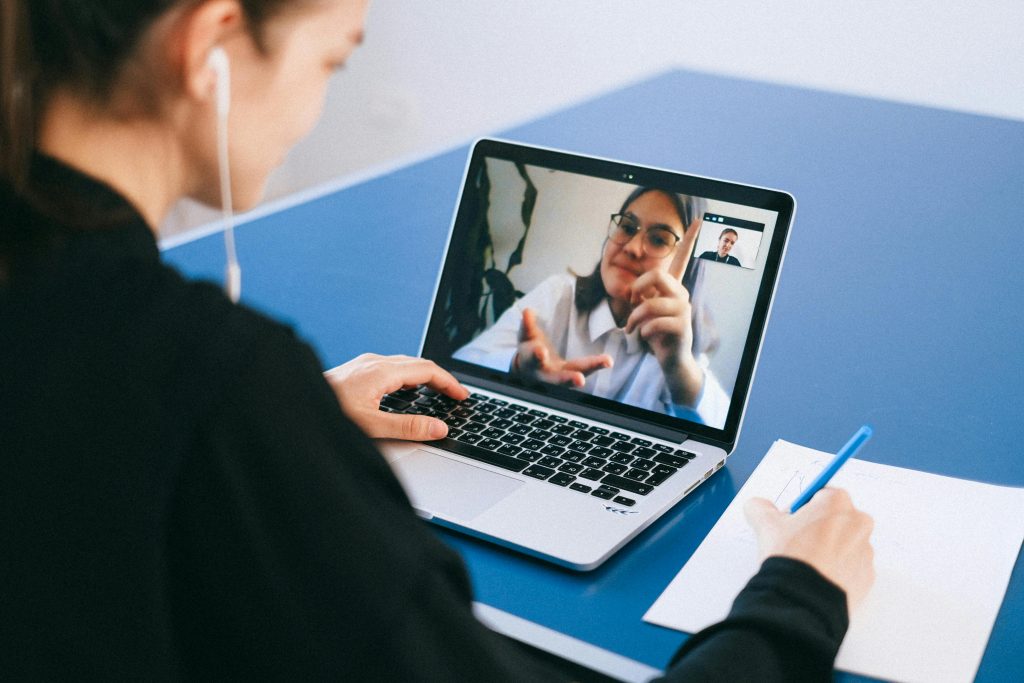 pexels photo 4226256 4226256 Woman participating in a virtual meeting, taking notes during a video conference on a laptop.